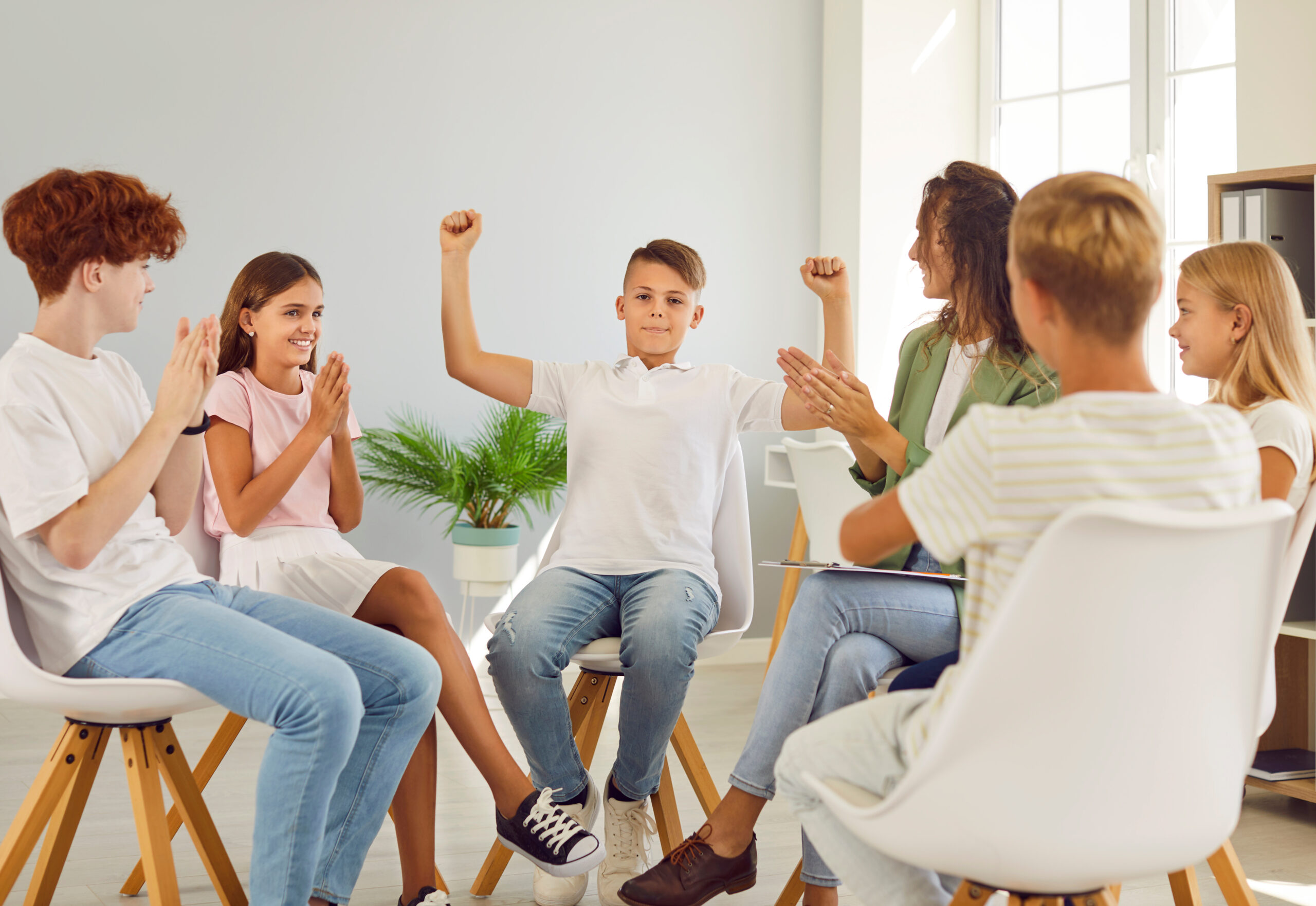 Friendly woman conducting psychological training for a group of school children.
